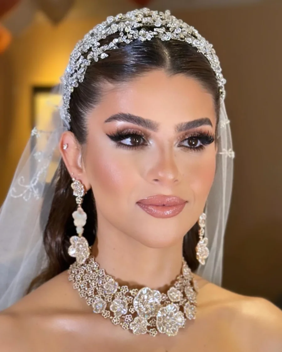 Bride wearing a crystal headpiece and cathedral veil — radiant soft-glam bridal makeup by luxury bridal makeup artist Aya Abdelhamid